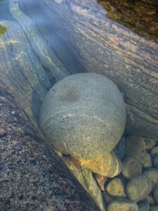 big smooth rock in water